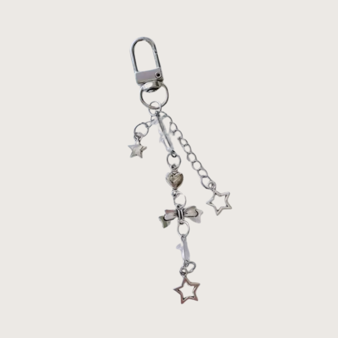 Silver keychain or bag charm with small stars and bow charms on a white background