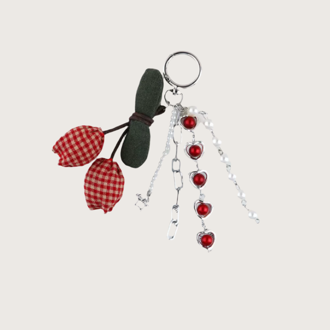 Bag Charm with red checkered cherries and heart-shaped beads on a light gray background