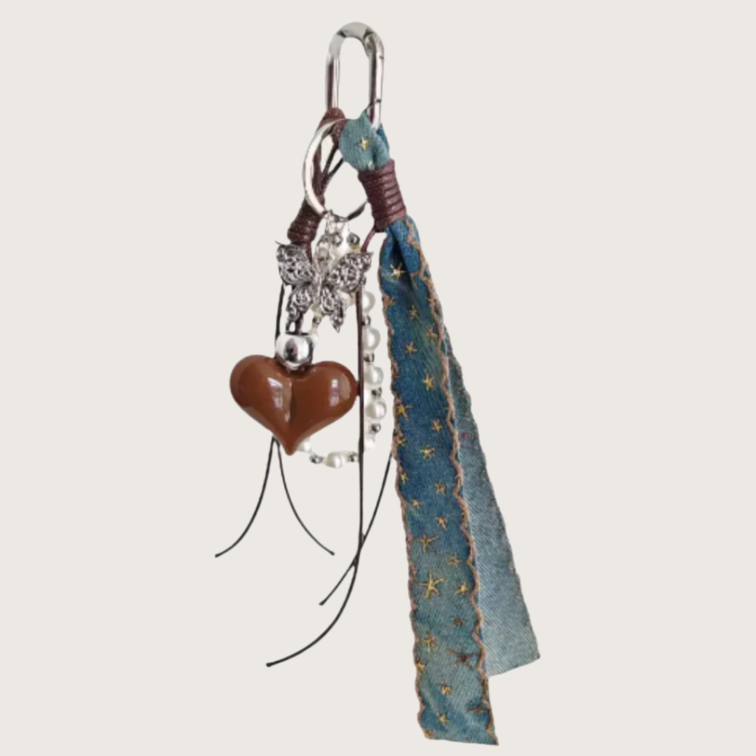 Decorative Bag Charm with heart-shaped charm, butterfly-shaped charm, and blue denim ribbon.