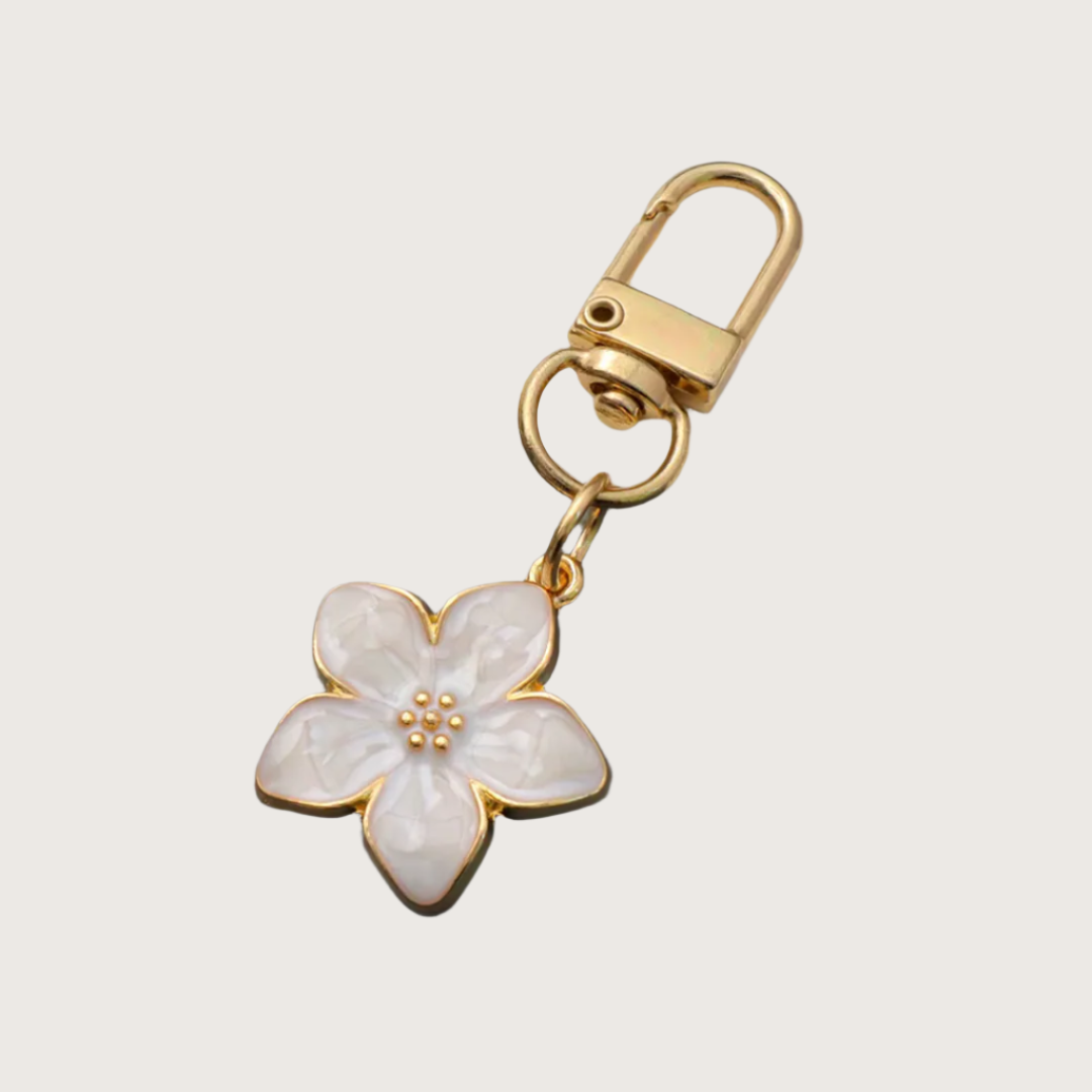 White Floral keychain or bag charm with gold accents.