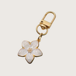 White Floral keychain or bag charm with gold accents.